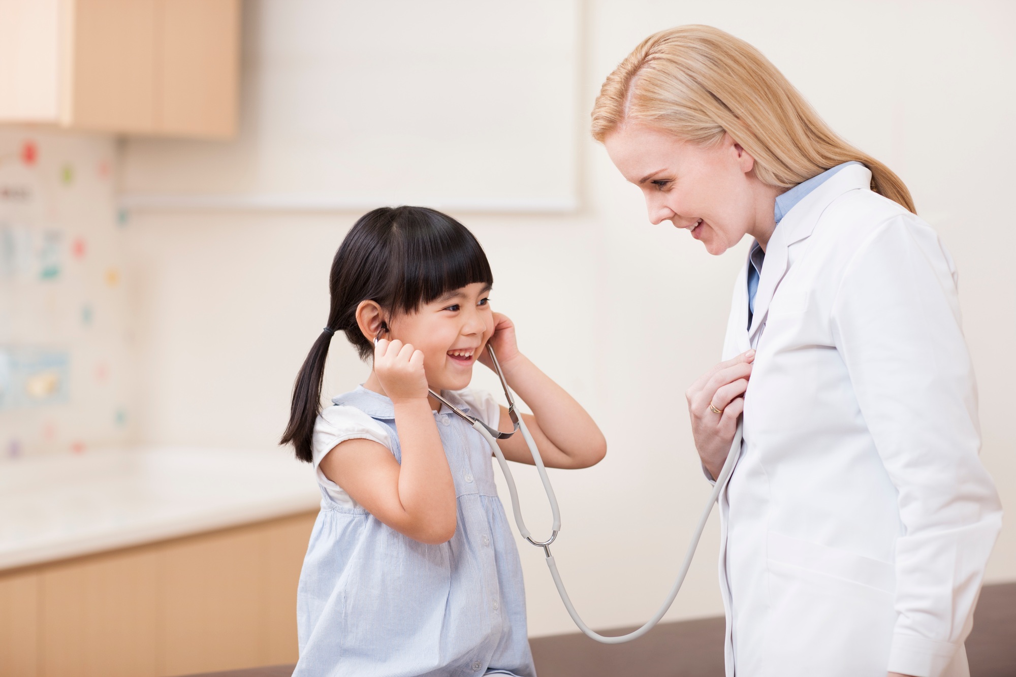 Happy doctor and girl with stethoscope